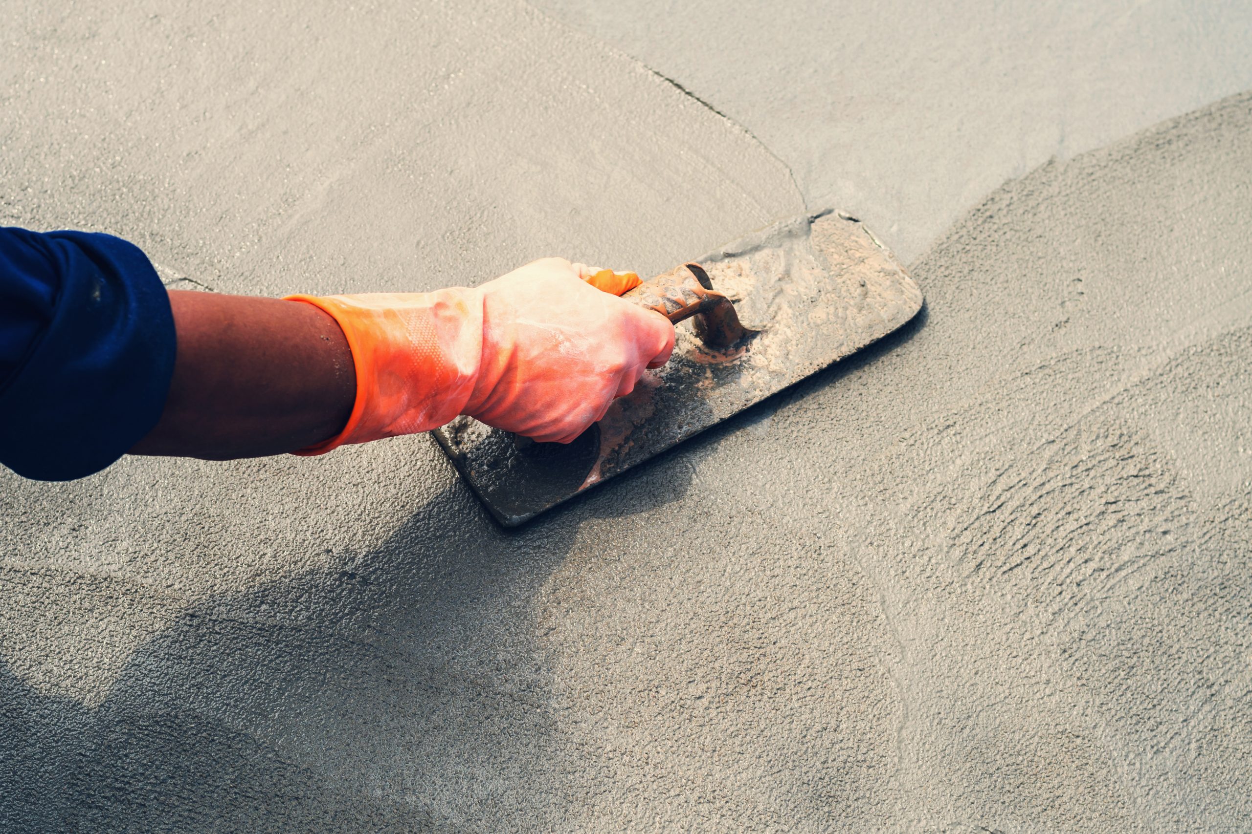 Close up hand worker leveling concrete pavement for mix cement at construction site